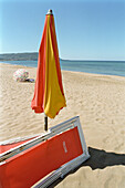 Red deck chair and a sunshade on the beach, sea, Castellabate, Cilento, Italy