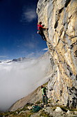 Climber at Schuesselkar rock face in the sunlight, Tyrol, Austria, Europe