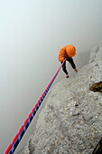 Kletterer beim Abseilen im Nebel, Tirol, Österreich, Europa