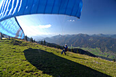 Person paragliding near Lake Tegernsee, near Rottach-Egern, Tegernsee, Upper Bavaria, Bavaria, Germany