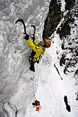 Young woman ice climbing, Engadin, Grissons, Switzerland, Europa