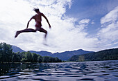 Young man jumping into lake Lago di Levico, Valsugana, Trentino-Alto Adige/Südtirol, Italy