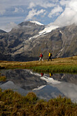 Wanderer vor einem Bergsee unter Wolkenhimmel, Hohe Tauern, Österreich, Europa