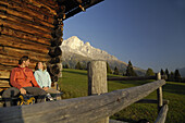 Paar rastet vor einer Hütte, Rosengarten, Dolomiten, Trentino-Südtirol, Italien