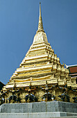 Guardian mythical demons supporting golden chedi, Grand Palace, Bangkok, Thailand