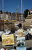 Paintings for sale on display on quayside, Honfleur, Normandy, France