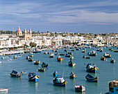 View of bay with colourful fishing boats, Marsaxlokk, Malta, Maltese Islands