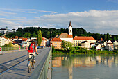 Female cyclist passing bridge over river Inn, Danube Cycle Route Passau Vienna, Passau, Lower Bavaria, Bavaria, Germany