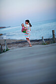 Mädchen mit Baby am Steg, Formentera, Balearen, Spanien