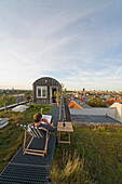 Mann in einem Liegestuhl auf einem Dach, Kreuzberg, Berlin, Deutschland
