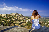 Young woman taking a picture of the village Gordes, Vaucluse, Provence, France, Europe