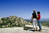 Couple looking at the village Gordes, Vaucluse, Provence, France, Europe