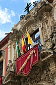 Colourful flags on ornate balcony, Seville, Andalucia, Spain