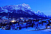 View of town and Dolomites at night in winter, Cortina d'Ampezzo, Trentino-Alto Adige, Italy