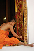 Mönch bemalt Fensterrahmen, Restaurationsarbeiten am Wat Phra Si Rattana, Si Satchanalai Chalieng Geschichtspark, Provinz Sukothai, Thailand, Asien