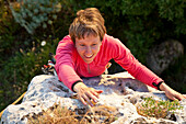 Frau mittleren Alters klettert, Provinz Sassari, Sardinien, Italien, Europa