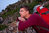 Wanderer lehnt sich an einen Felsen und rastet, Jerzu, Sardinien, Italien, Europa