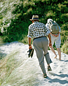 Old couple wandering through sanddunes towards Wharariki Beach, Northwest coast, South Island, New Zealand