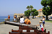 Touristen an einer alten Kanone auf der Bastion, Alghero, Sardinien, Italien, Europa