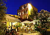 Menschen auf der beleuchteten Terrasse des Hotel Restaurant Sa Pischedda am Abend, Bosa, Sardinien, Italien, Europa