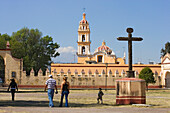 Familie läuft über den Vorplatz des Ex-Convento de San Gabriel, im Hintergrund ist die Iglesia de San Pedro, Cholula, Bundesstaat Puebla, Mexiko
