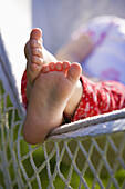 Close up of a girl´s feet resting on a hammock