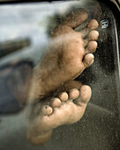 close up colorful shot of a cab drivers feet in car window taking a nap..