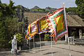 Colourful flags in front of a temple at the Ninh Binh Province, Vietnam, Asia