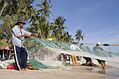 Fishermen with fishing net on the beach of Mui Ne, Binh Thuan Province, Vietnam, Asia