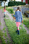 Two girls (6-9 years) with fresh carrots, Lower Saxony, Germany