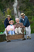 Älteres Paar genießt Korbschlittenfahrt in Monte, Funchal, Madeira, Portugal