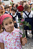 Girl holding a rose during the Childrens Parade at the Madeira Flower Festival, Funchal, Madeira, Portugal