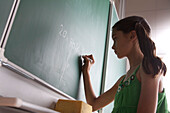 Schoolgirl writing on blackboard, Hambug, Germany
