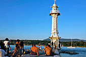Bathing And Relaxing In Front Of The White Lighthouse Of The Bains Des Paquis In The Geneva Harbour On Lake Geneva, Geneva, Switzerland