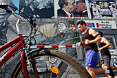 Joggers, East Side Gallery (Mauer Galerie), The Open-Air Gallery Of The Muhlenstrasse, With Works By 118 Artists From 21 Countries, Makes Up The Longest Preserved Section (1, 300M) Of The Old Wall. Created In January 1990, Berlin, Germany