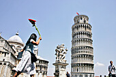 Tourists In Front Of The Leaning Tower (Torre Pendente), Baptistery And Cathedral (Duomo) On The Campo Dei Miracoli, Pisa, Tuscany, Italy