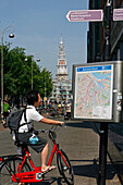 Tourist On A Bicycle In Front Of A Map Of The City, Jodenbreestraat Street, South Church, Zuiderkerk