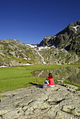 Frau rastet am Stubensee, Stubaier Alpen, Trentino-Südtirol, Italien