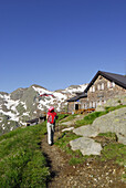 Female hiker arriving Magdeburg hut, Stubai Alps, Trentino-Alto Adige/South Tyrol, Italy