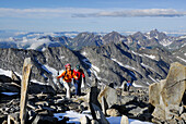 Drei Bergwanderer steigen zwischen Steinmännern zum Hochfeiler auf, Zillertaler Alpen, Südtirol, Italien