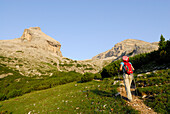 Woman hiking, Conturinesspitze and La Varella in background, Naturpark Fanes-Sennes-Prags, Dolomites, Trentino-Alto Adige/South Tyrol, Italy