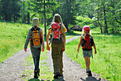 Drei Mädchen wandern entlang einer Wiese, Bayerische Alpen, Oberbayern, Bayern, Deutschland