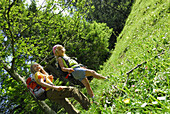 Zwei Mädchen wandern über eine Wiese, Bayerische Alpen, Oberbayern, Bayern, Deutschland