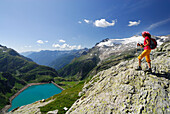 Wanderin blickt über Stausee Lago di Robiei, Basodinogletscher im Hintergrund, Tessiner Alpen, Tessin, Schweiz