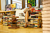Woman sitting in a bookshop, Leipzig, Saxony, Germany