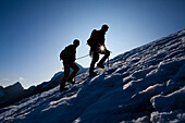 Two mountaineers ascending over icefield, Clariden, Canton of Uri, Switzerland