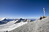 Zwei Männer rasten beim Gipfelkreuz, Clariden, Kanton Uri, Schweiz