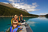 Family in paddle boat, Moraine Lake, Banff National Park, Alberta, Canada