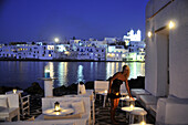 Frau auf einer Restaurantterrasse am Abend, Naoussa, Insel Paros, Kykladen, Griechenland, Europa