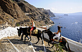 Touristen reiten auf Eseln, Fira, Santorin, Kykladen, Griechenland, Europa